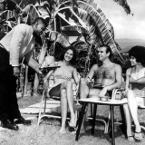 Seated by the side of a huge palm tree, Scotish Irish actor Sean Connery relaxes with Diane Diaz, Jamican model and Shirley Thurllew (right) a former Miss Jamica at Courtleigh Manor Hotel Kingston Jamaica. 26th January 1962